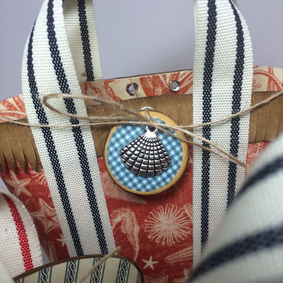 Thread one tail of the twine through the charm/chipboard and the other tail above it. Tie tails into a bow.