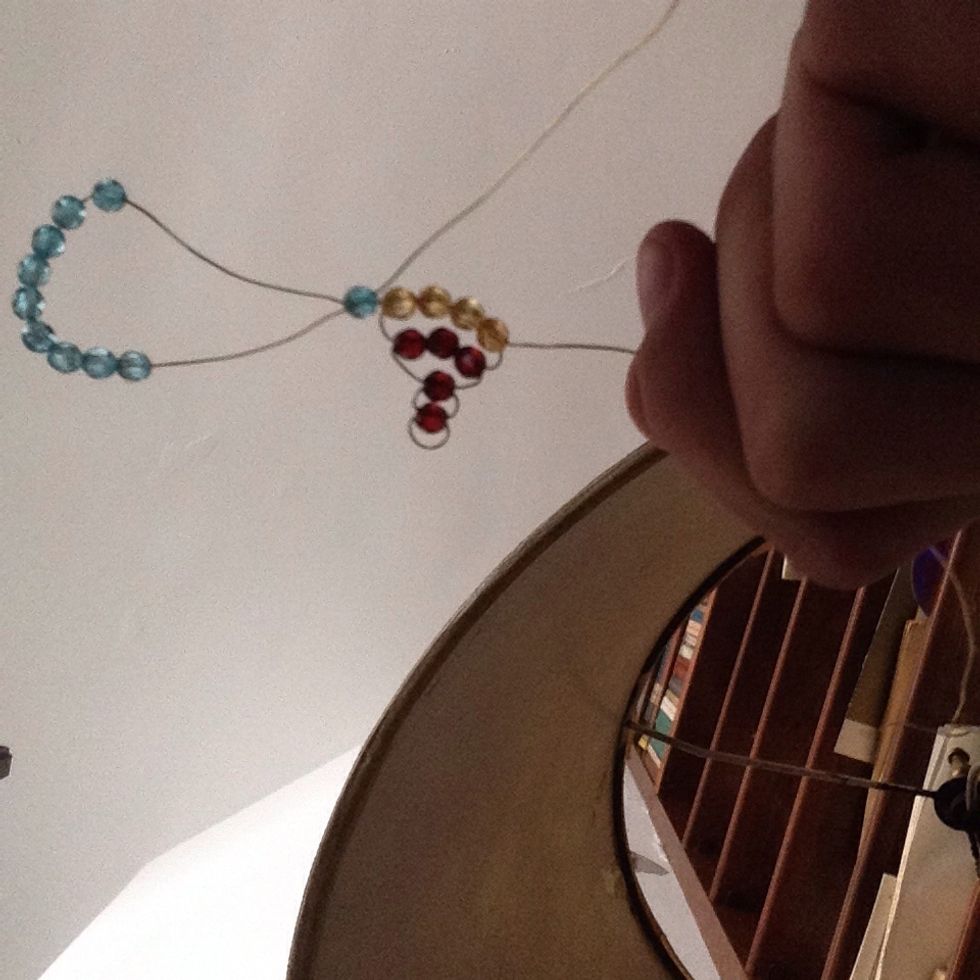 Thread the end of the wire back threw the first bead,repeat on the other side(tap to see full image)