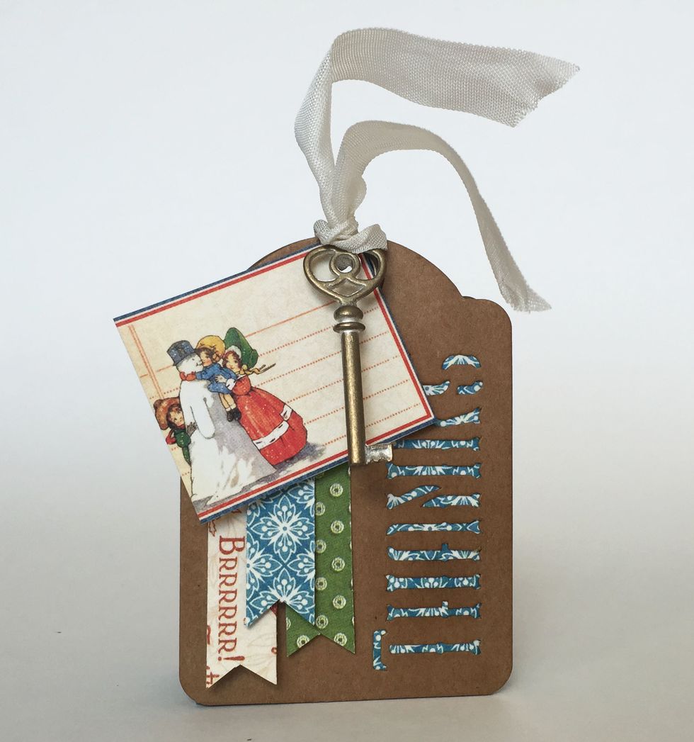 Thread the folded end of the seam binding through the holes of each \u2018Thanks\u2019 tag.