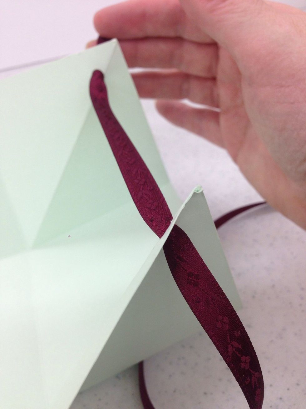 Thread the ribbon in and out of each hole around the basket.