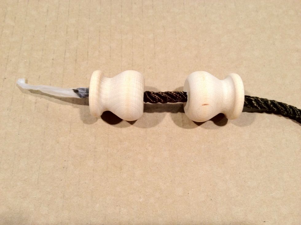 Thread two of the wooden tassel forms onto the twist cord as shown. Slide the forms to each end of the twist cord being careful not to allow them to slip off. .