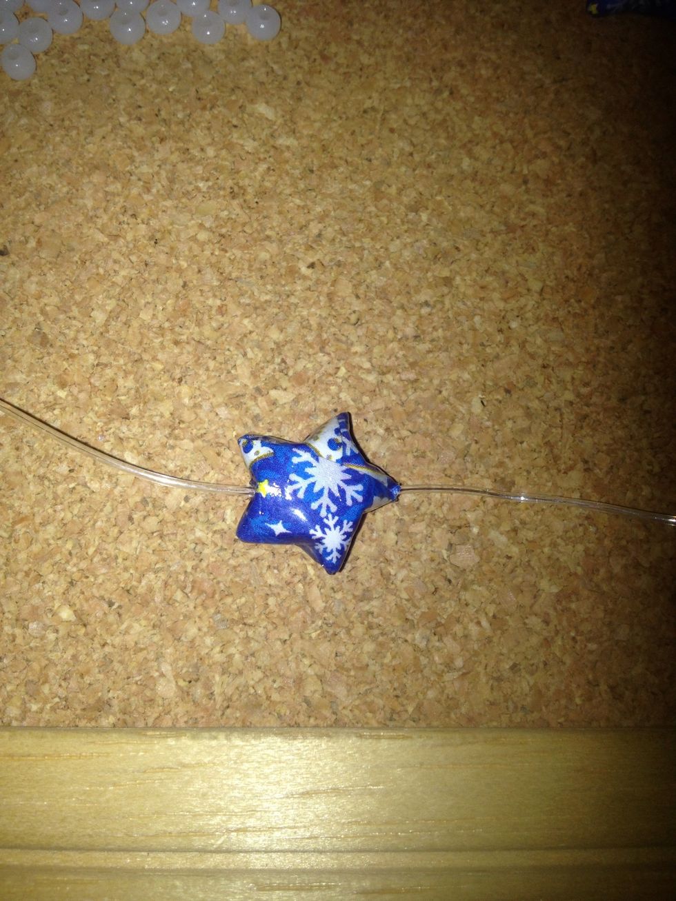 Thread your first star and take the needle off the cord. Since the eye of the needle is bigger,  it will not go through your beads.