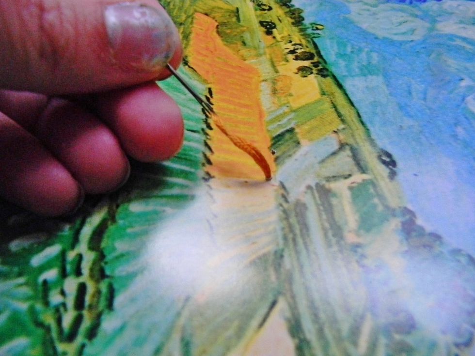 Thread your fist color onto your needle and poke it through the back of the calendar page to begin stitching. Don't poke the holes too closely together, though, so the paper doesn't rip.