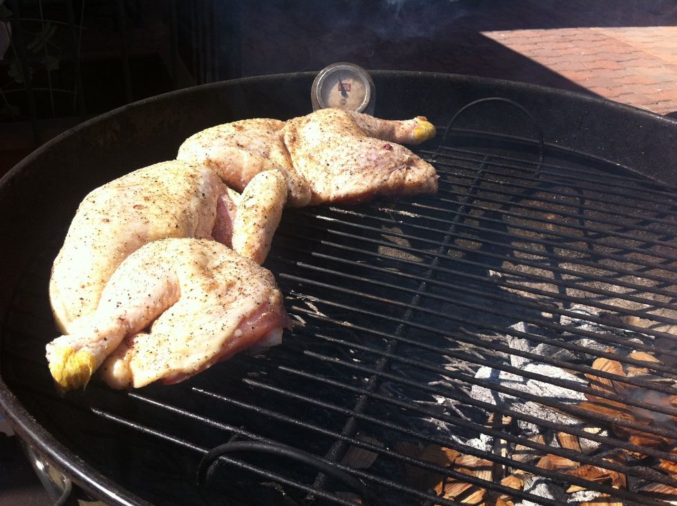 Throw a handful of woodchips on the coals and arrange your chicken with the tits facing away from the fire.. Cover and close the bottom vents about 1/2 way..