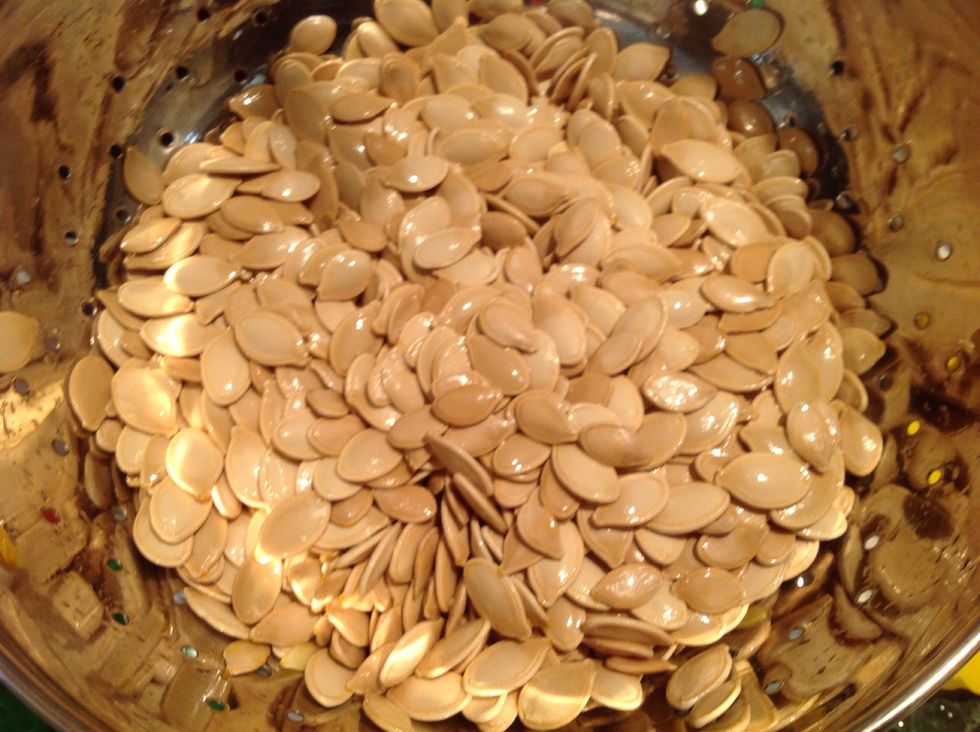 Throw all of the clean pumpkin seeds into another strainer to get the water out.