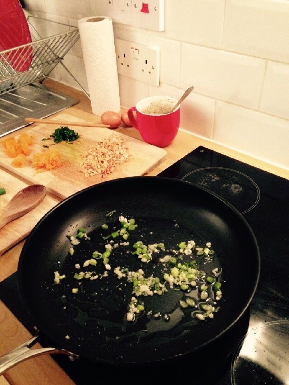 Throw in the garlic and the bottoms of the scallions. Stir fry without burning.