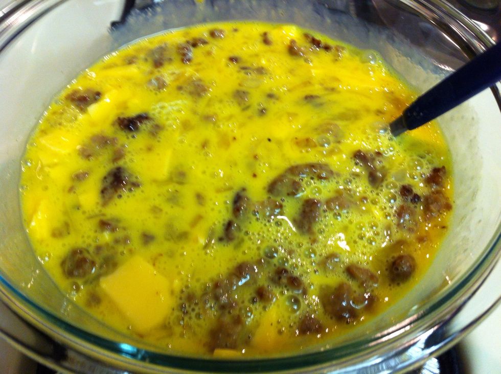 Throw onions, sausage, crumpled cheese in scrambled eggs and mix. Throw in some half-and-half to try to keep eggs creamy if you so desire