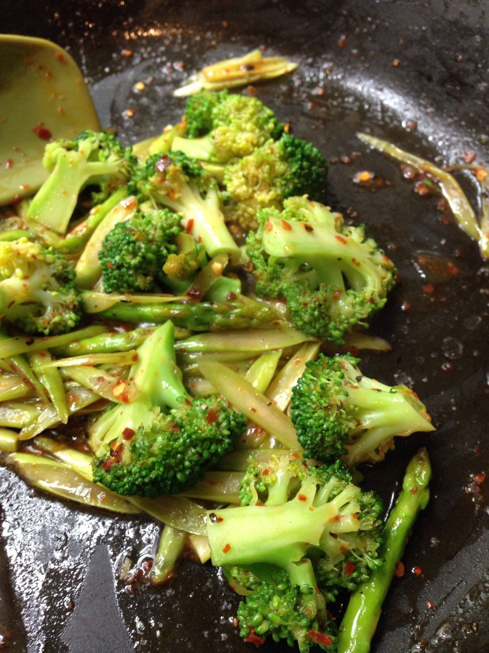 Throw the blanched broccoli into the pan of asparagus. Stir well under low heat.