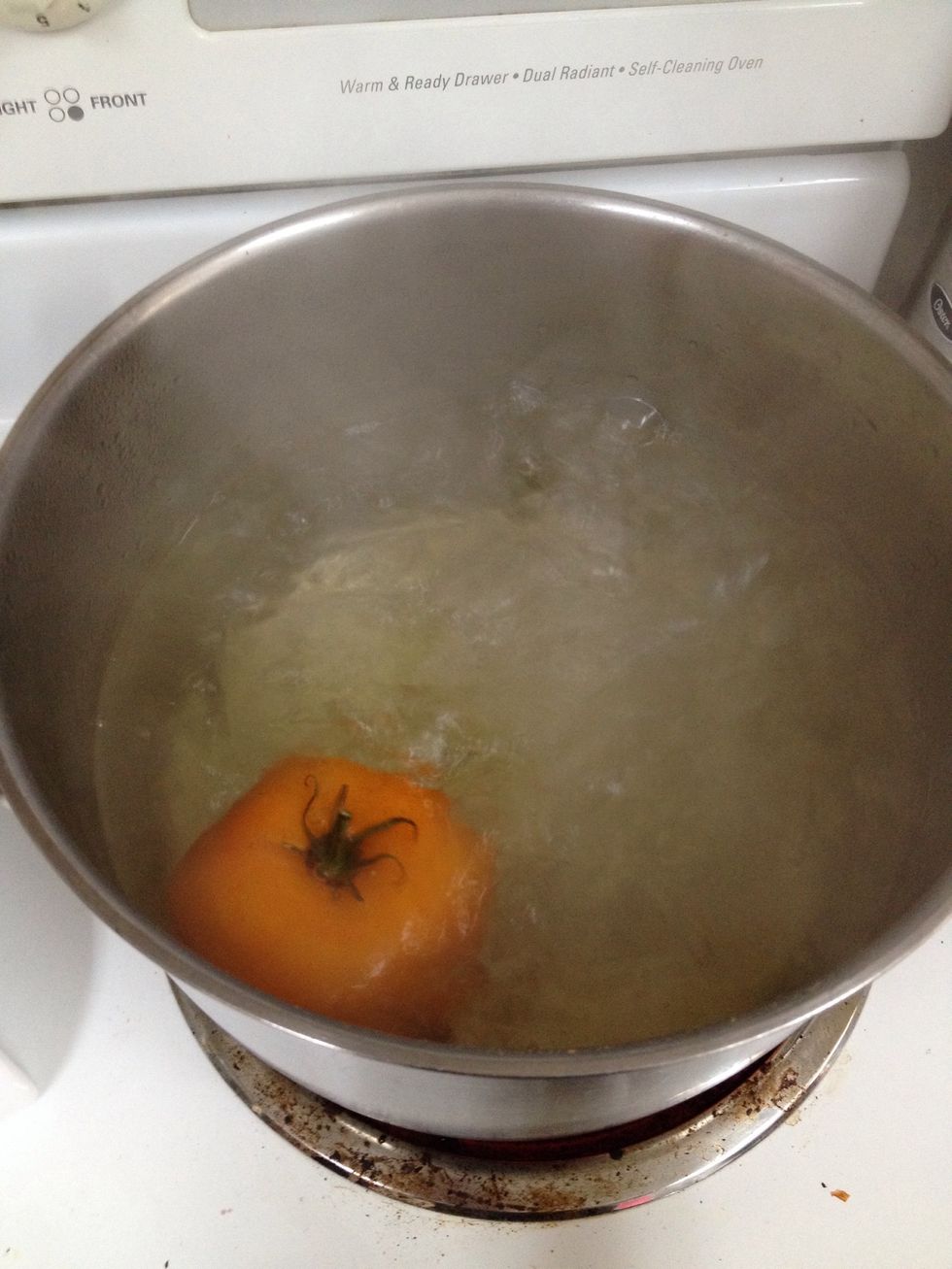 Throw your tomatoes about four at a time in a pot of boiling water. Count to 10 and check to see if they're peeling. If not, throw back in and count to 10 again.