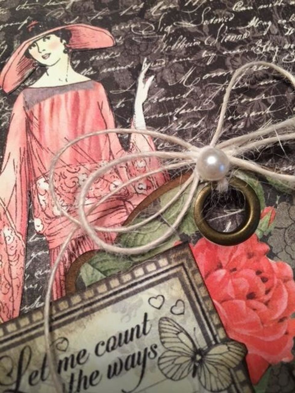 Tie a double loop button twine bow to the tag and add a flat back pearl.