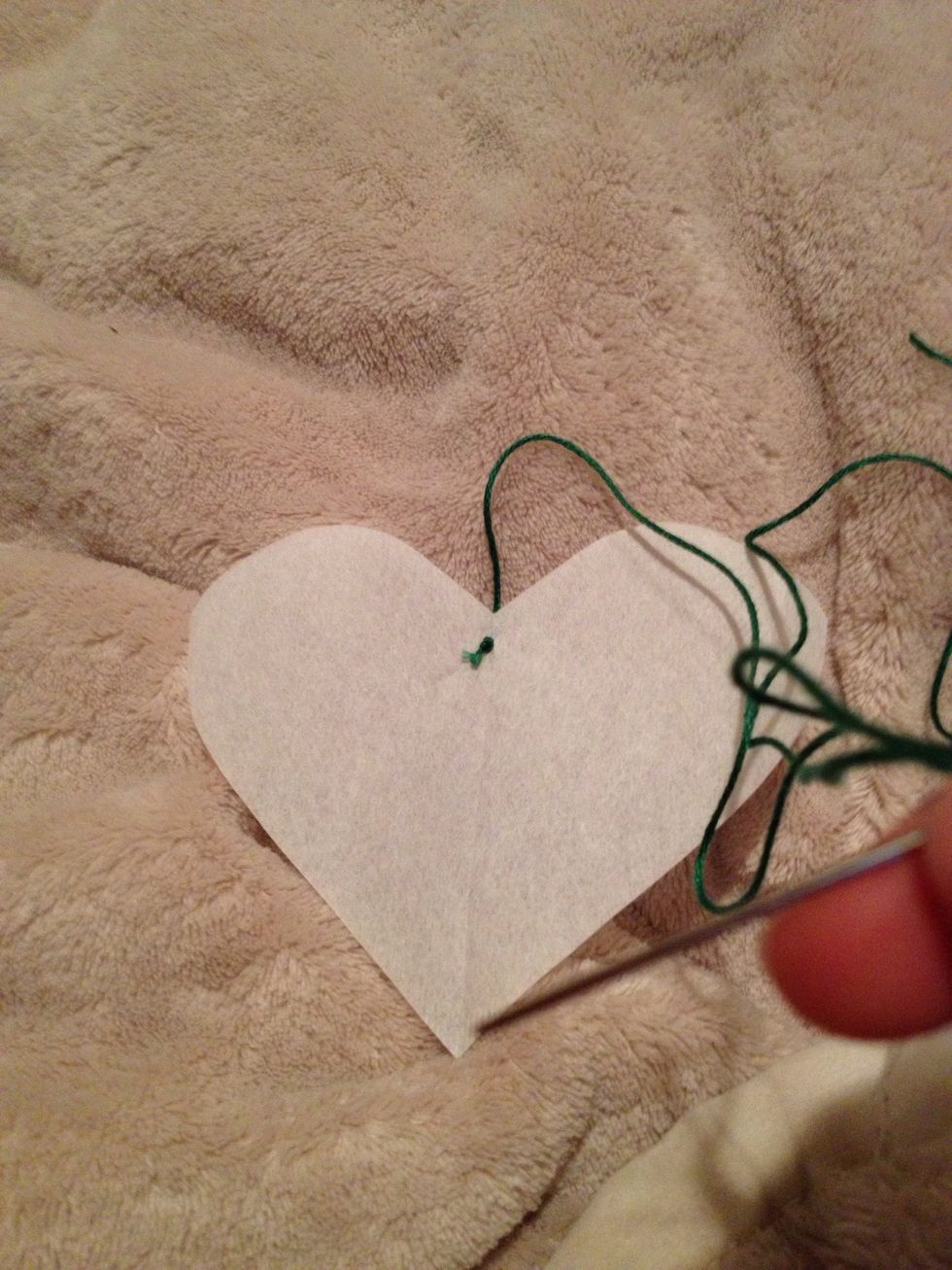 Tie a knot and put your first stitch through the top of the heart.