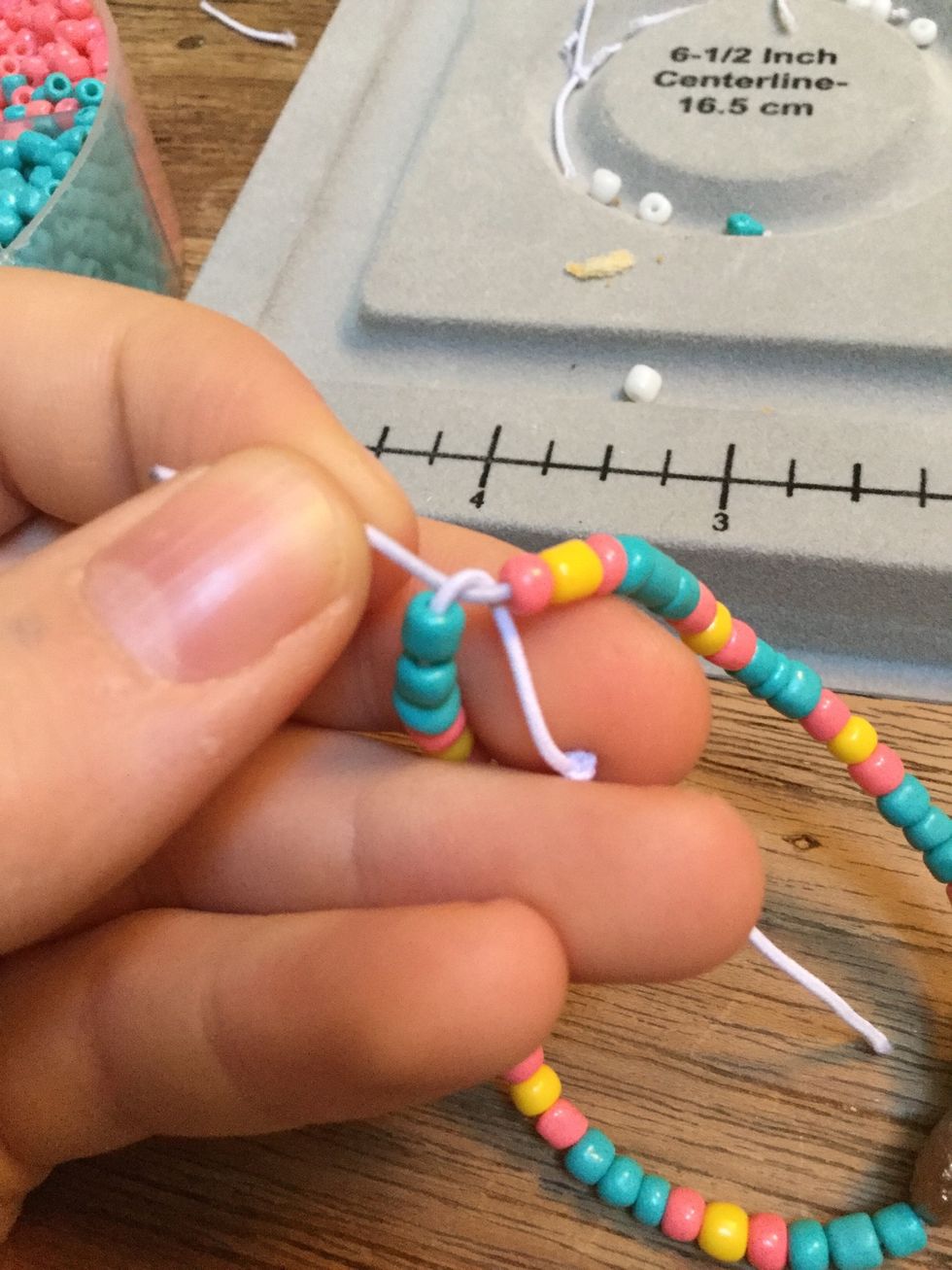 Tie a knot. Don't include the knot from the beginning. If you are using elastic cord, make sure you do not pull it tight, because it will not stretch.