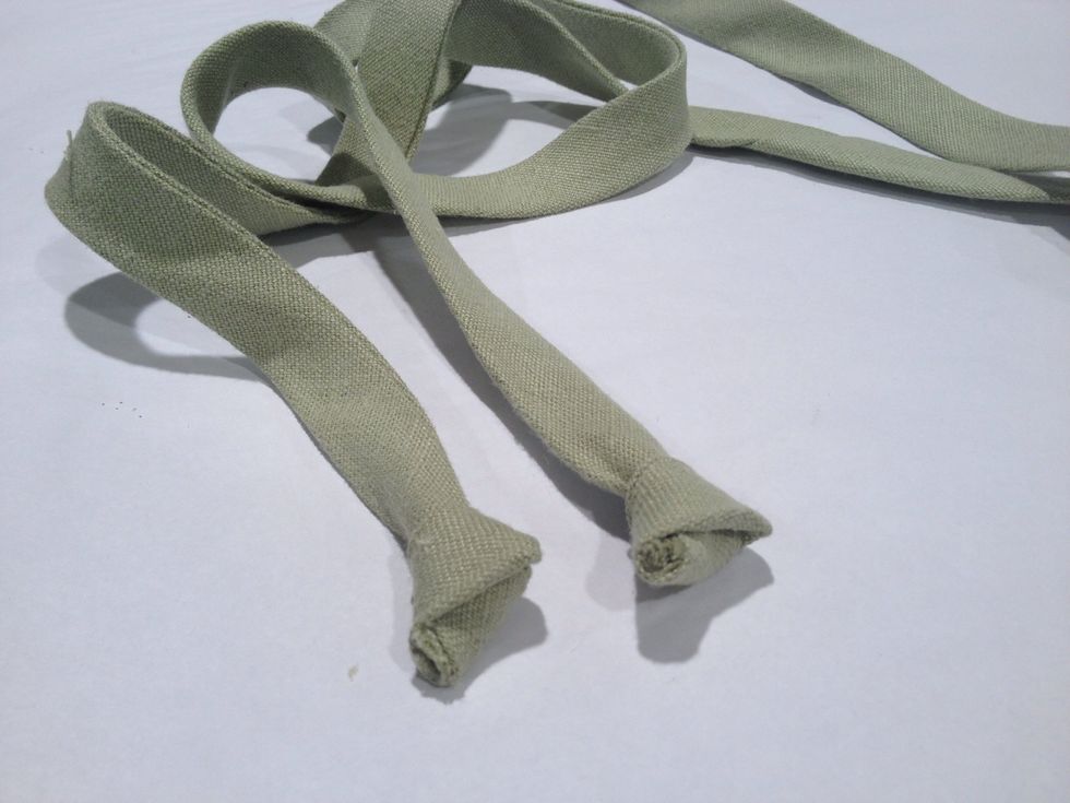 Tie a knot in each end of ties.