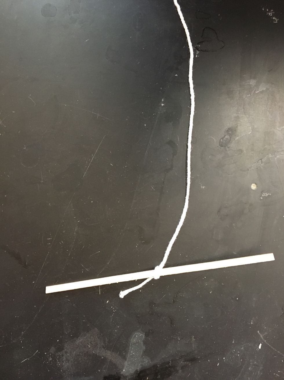 Tie a piece of string around a wooden splint.