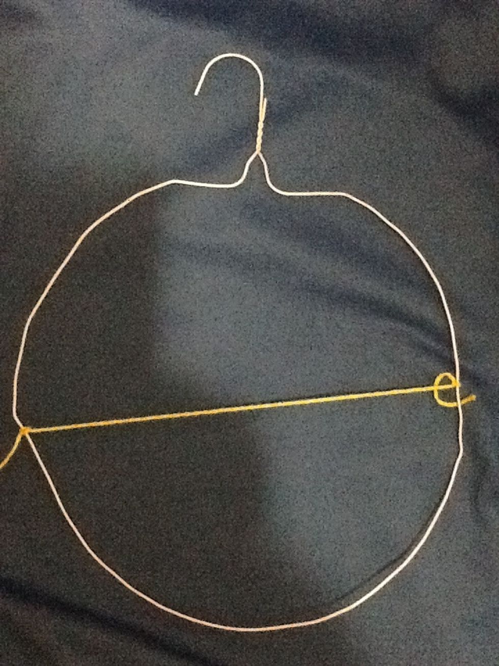 Tie a piece of yarn across the middle (diameter). Make it taut. Leave some yarn at end just in case.