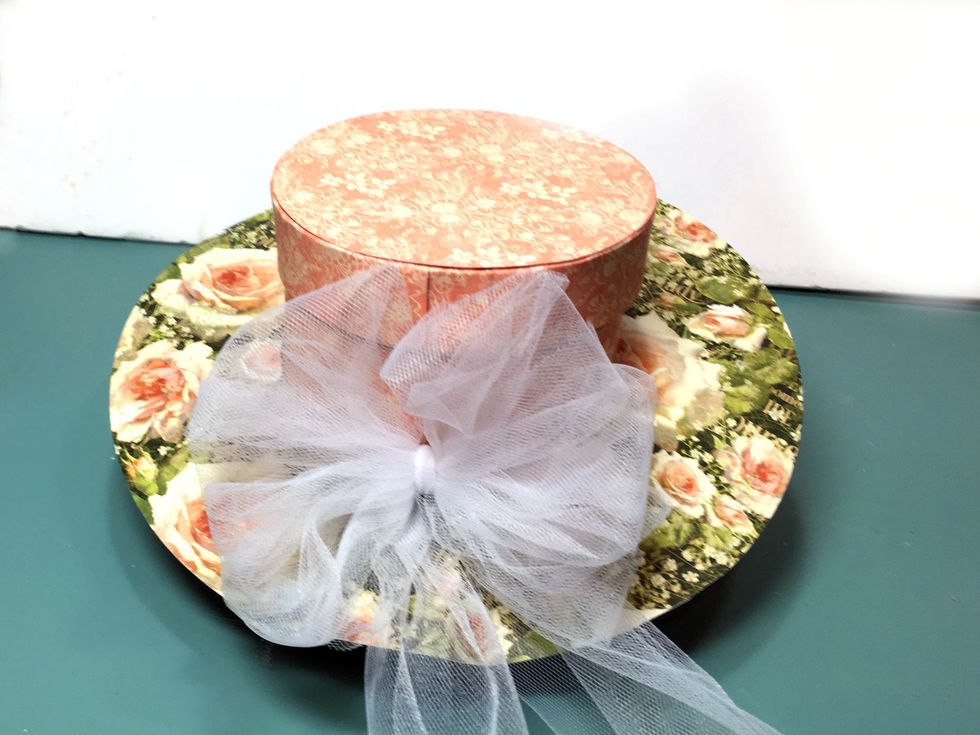 Tie a pretty box with the tulle and attach to the back of the hat at the paper seam.