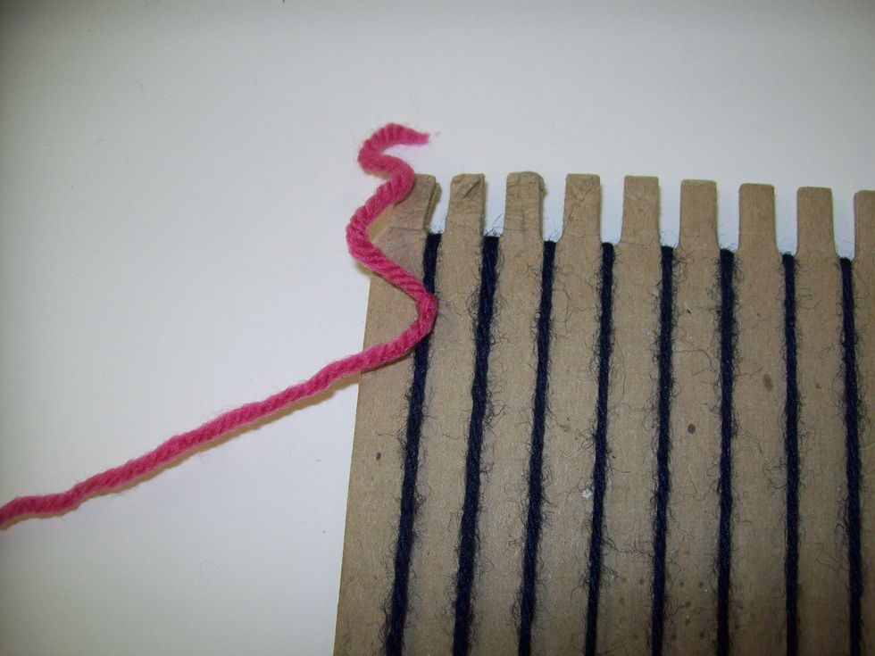 Tie a second wingspan of yarn onto the top of the 1st warp string. This second length of yarn will be called the weft.