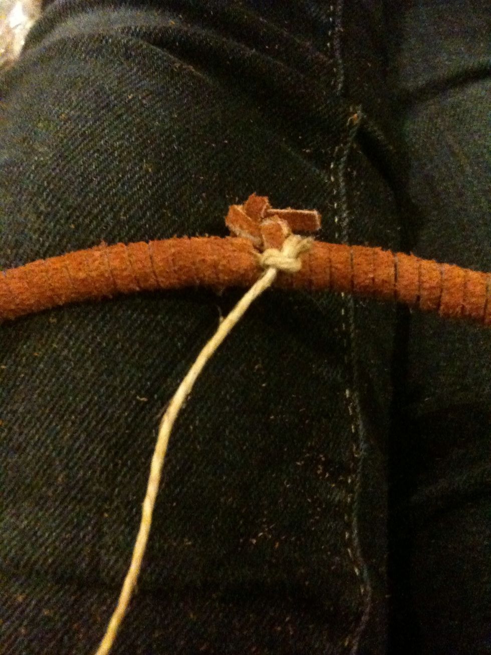 Tie a small knot with the sinew at the knot of the leather.