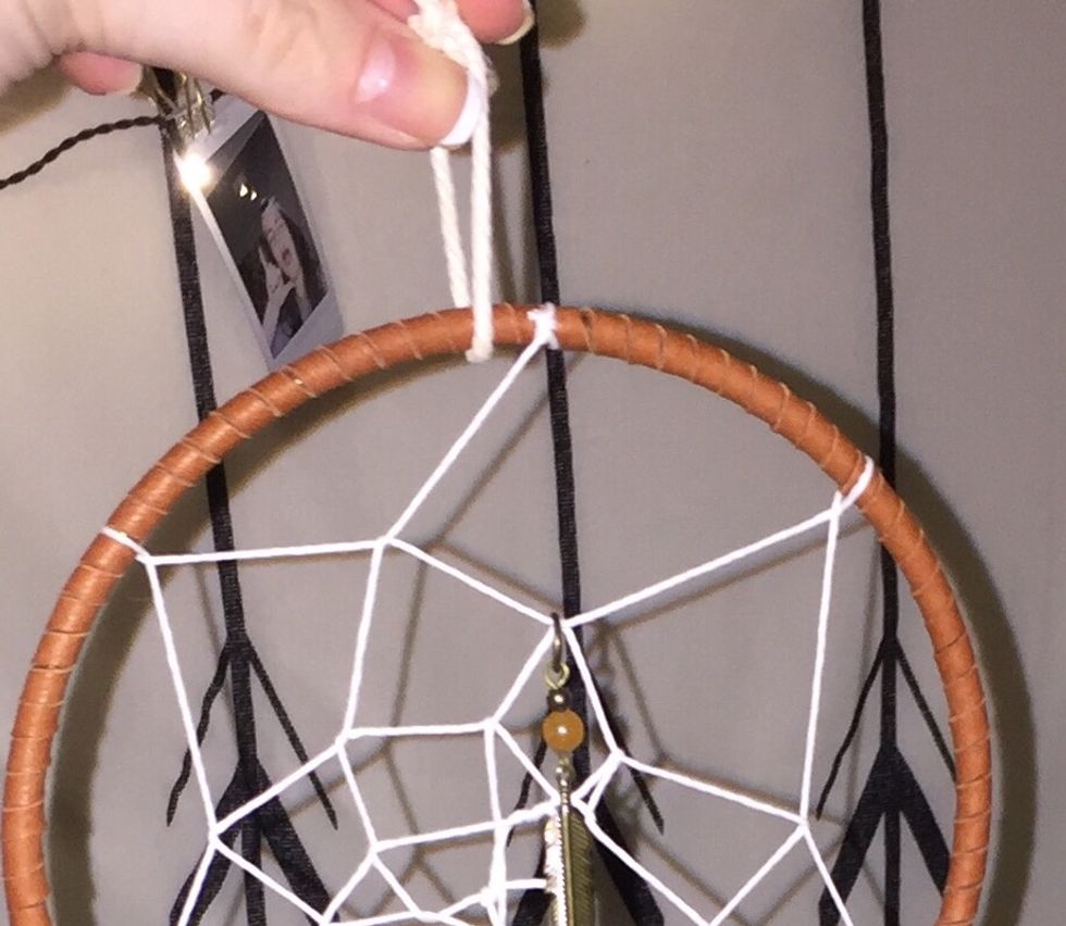 Tie a string into a loop at the top so you can hang the dream catcher.