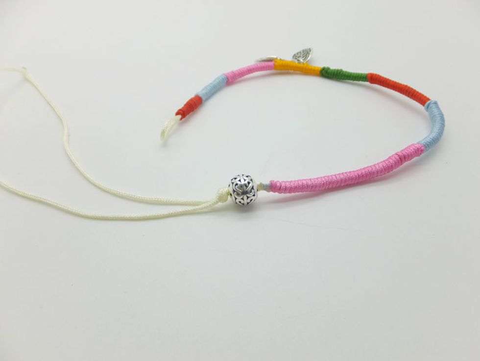 Tie an overhand knot after string a 925 sterling silver Hollow Bead.