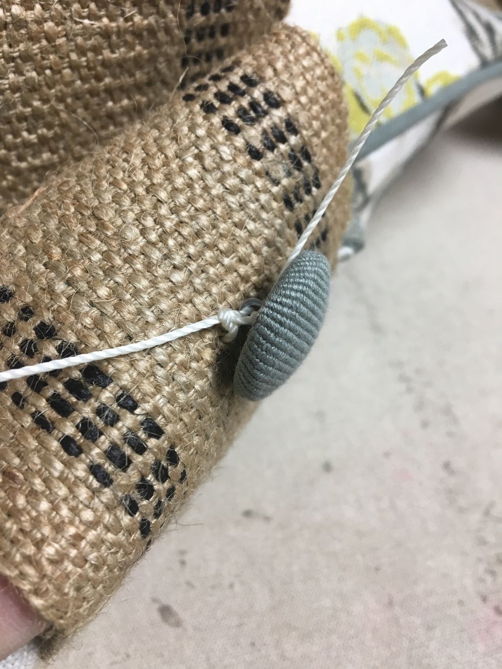 Tie each knot two or three times.  Tip: It helps to keep the button steady to put a drop of hot glue on the knot before clipping the ends off.