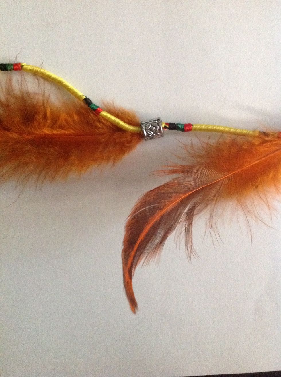 Tie feathers at a distance and slip in the bead onto the cord to hide the knot.