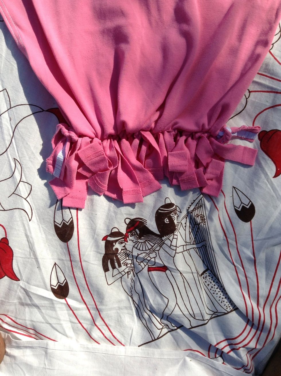 Tie knots along the bottom of the shirt holding pieces of the corresponding strips from either side. Tie 2 or 3 knots with each set of strips to make it secure.