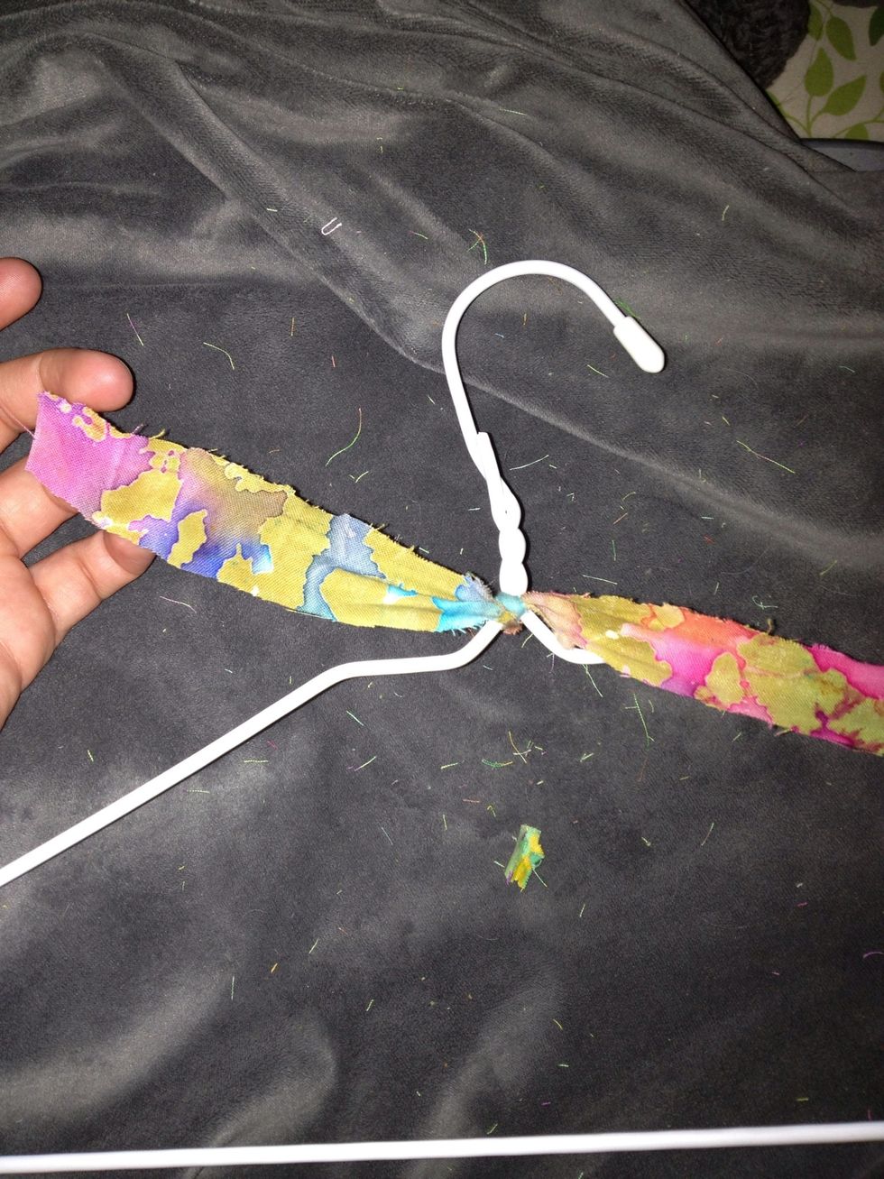 Tie the end of a strip to the top of the hanger leaving a little coming out