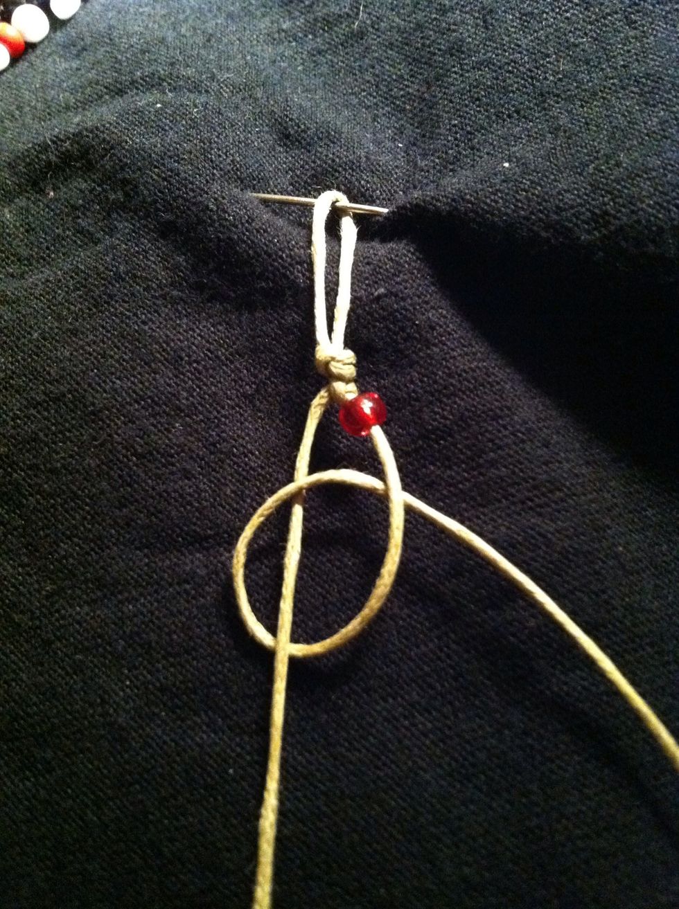 Tie the right strand over the left in a mirror image of step 10. Under, over, through, pull tight. Make sure the bead Is snug against knot.
