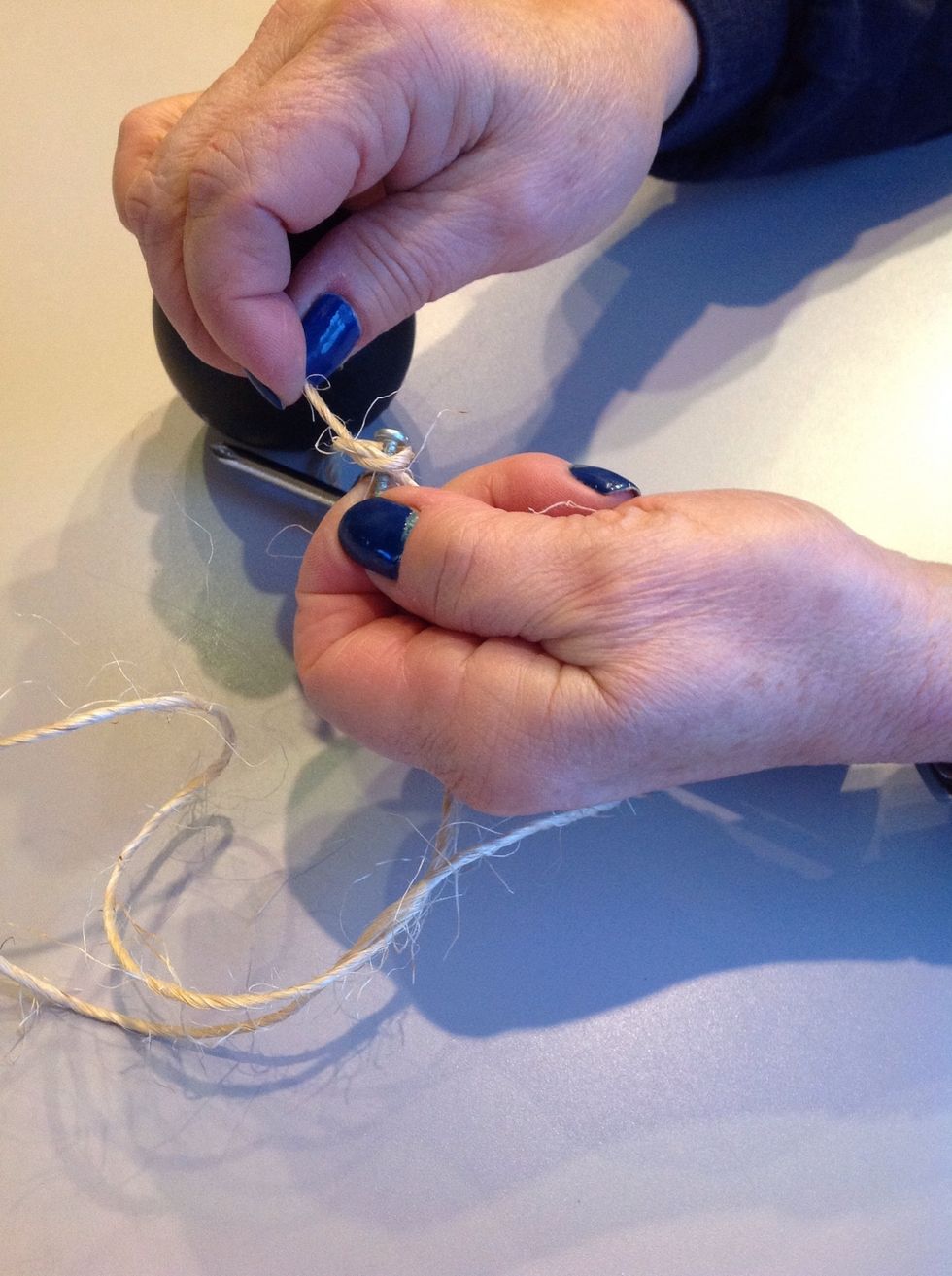 Tie the twine around the screw head.