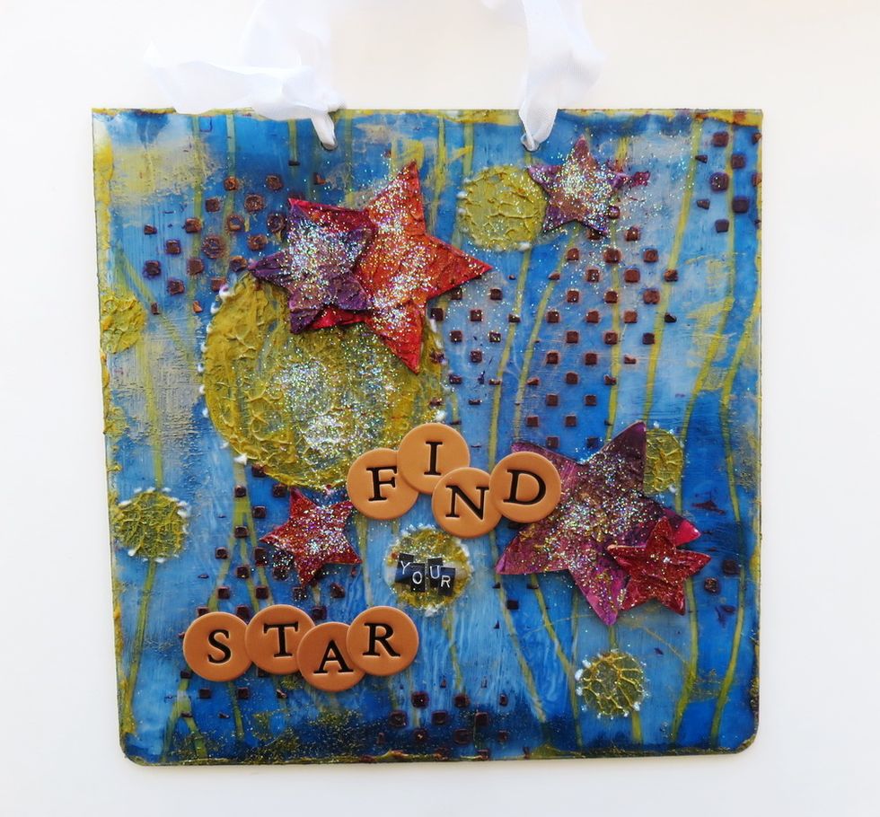 Tie the white silk ribbon on the top using the album holes. Add some clear glitter over the whole page.Paint around the edges with Vegas Gold paint.