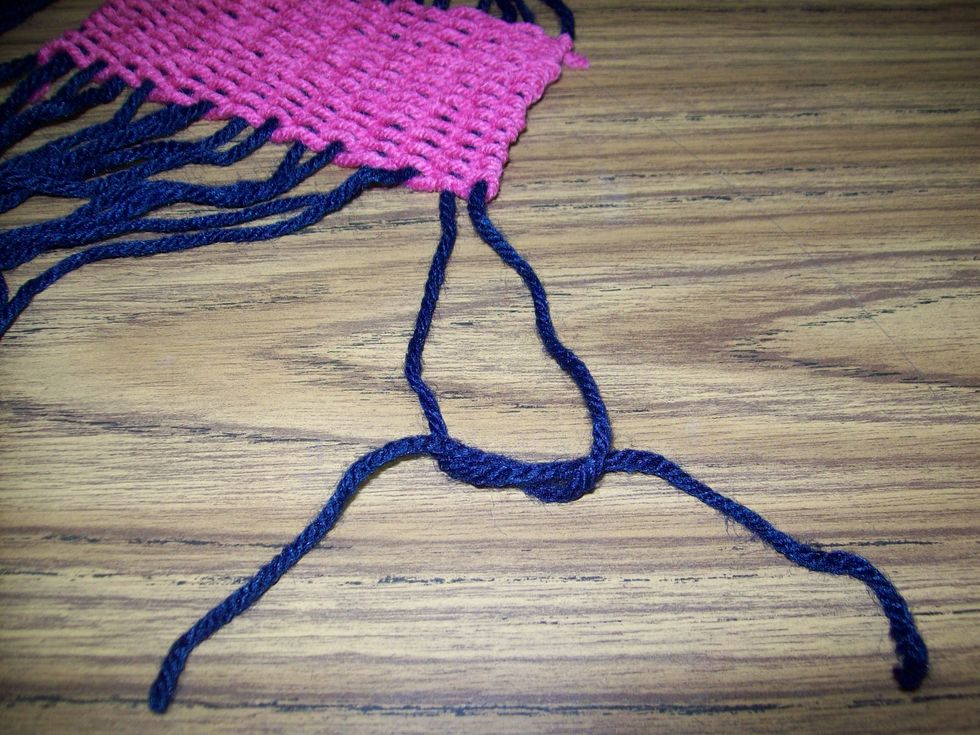 Tie those 2 strings together in a simple knot pulled up to the weft, but not into the weft.
