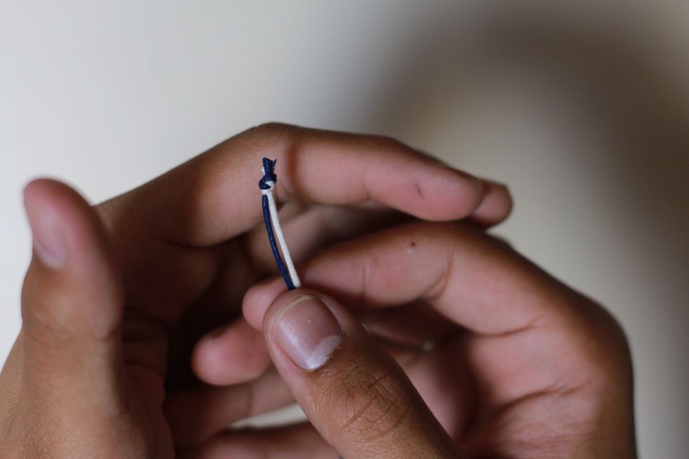 Tie two color cords of your choosing together. Like so in the picture.