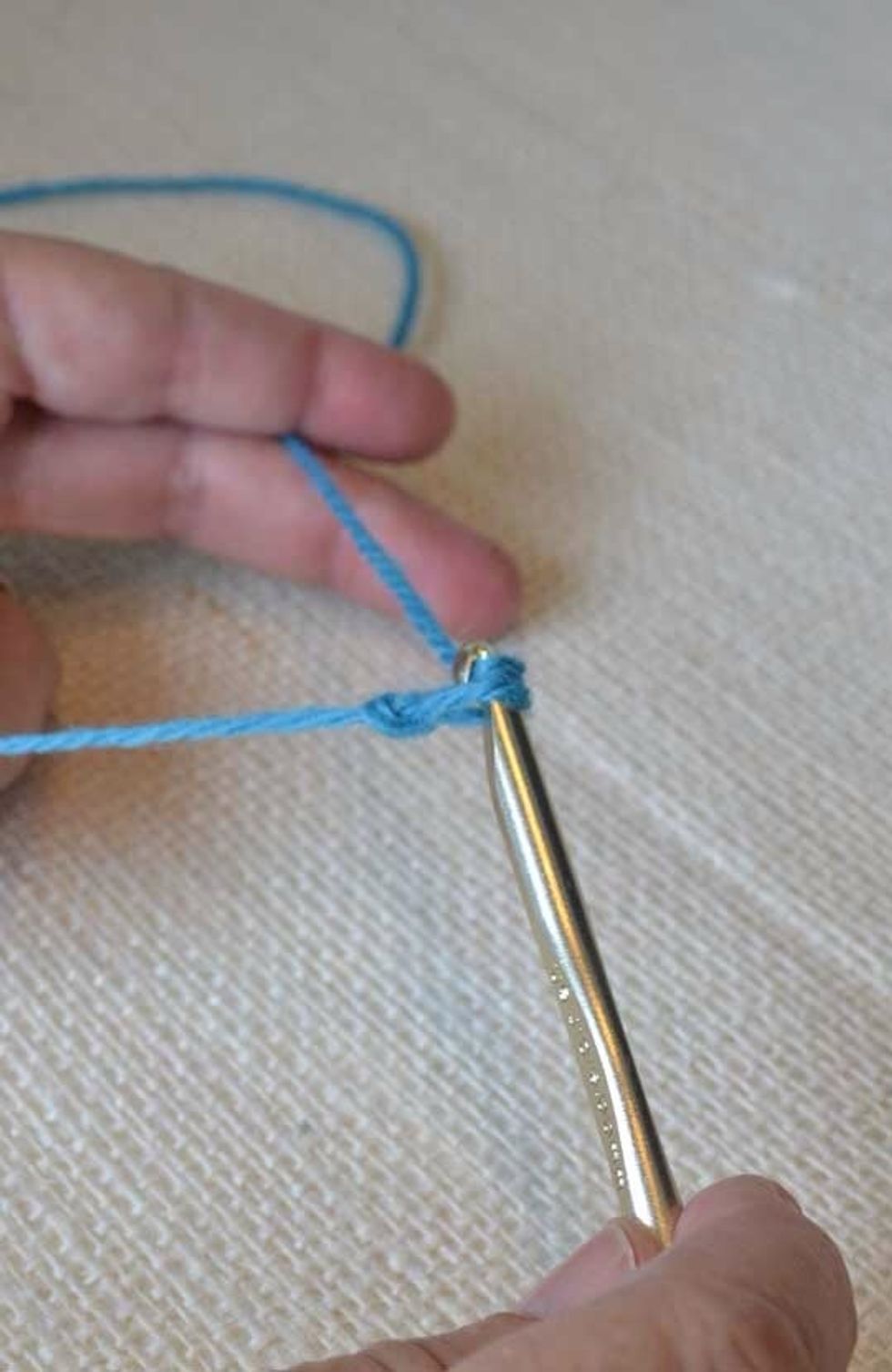 Tighten the first loop around the neck of the second.