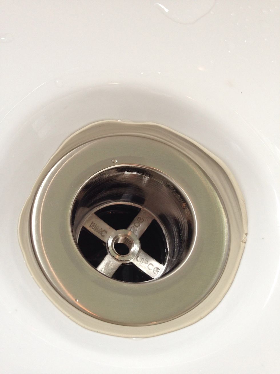 Tighten until you can't turn anymore. Some of the plumbers putty will squeeze out all around the edges.