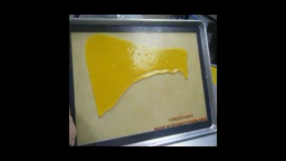 Tilt the sheet pan and tap it on the table to create a thin layer.