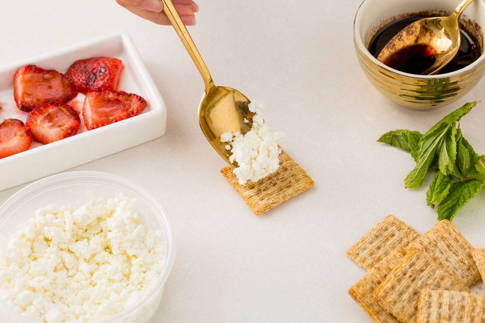 Time to assemble your cracker bite, by adding goat cheese to a TRISCUIT Cracker.