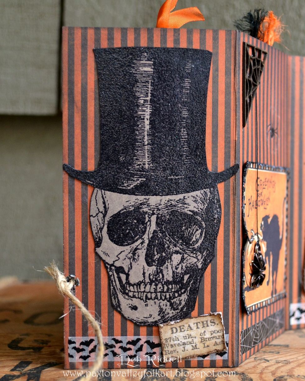 Time to decorate the back of the pocket pages! Stamp the large skull from the Undertaker set onto grey cardstock, clear emboss and fussy cut the image and adhere in place.