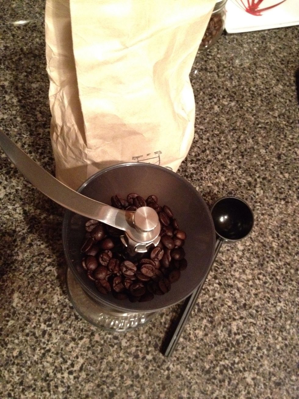 Time to grind the beans. Use your AeroPress scoop and place 2 full scoops of beans into the grinder. You should also start to boil 10 - 12 ounces of filtered water at this point.
