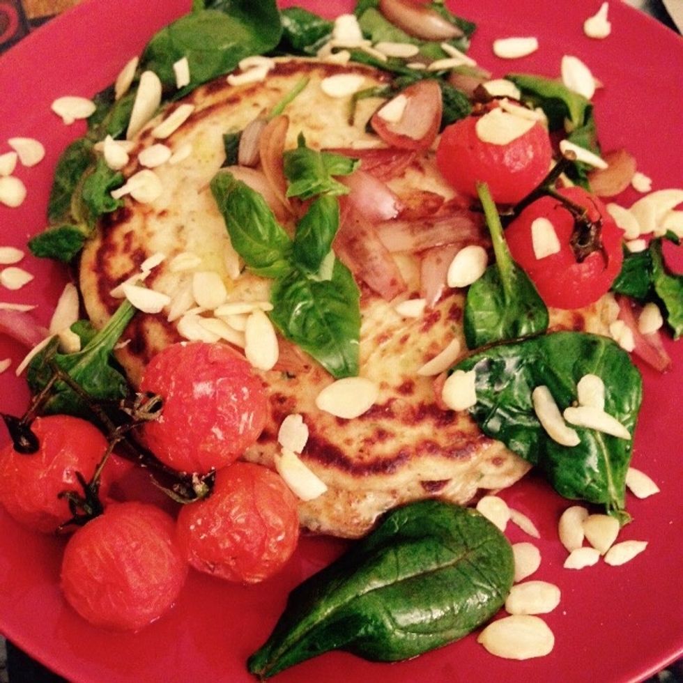 Time to plate the pancakes and garnish with the shallots and baby spinach vinaigrette, the roasted tomatoes and some shaved almonds sprinkled on top. Drizzle with olive oil and add few leaves of basil
