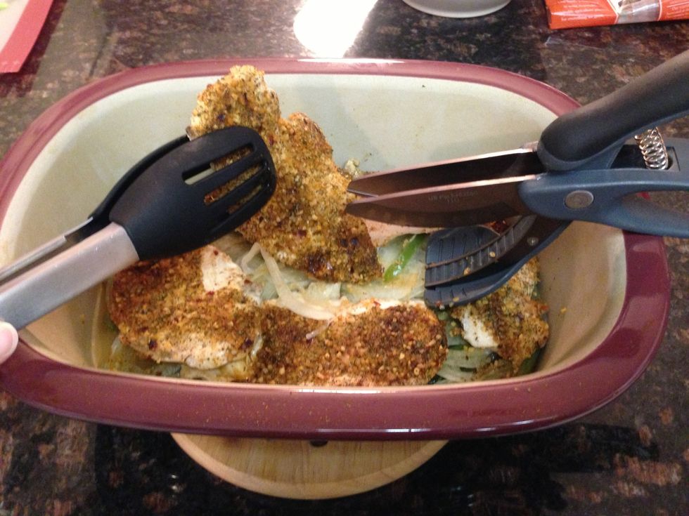 Time to slice the chicken. You can use a sharp knife on cutting board or. Try this! Using chef tongs, hold 1 chicken breast. Now with your other hand take The Pampered Chef Salad Coppers & cut chicken
