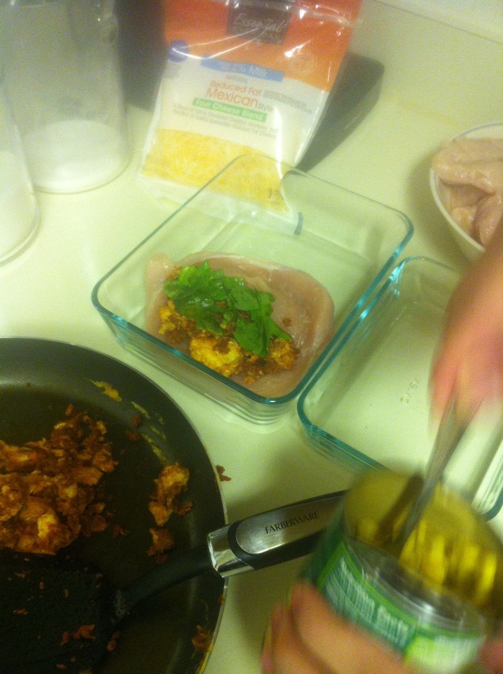 Time to stuff. In a casserole dish (mine was too small) place prepared chicken, stuff w/ chorizo and eggs, a spoonful of sweet canned corn, some fresh spinach leaves, and a little shredded cheese.