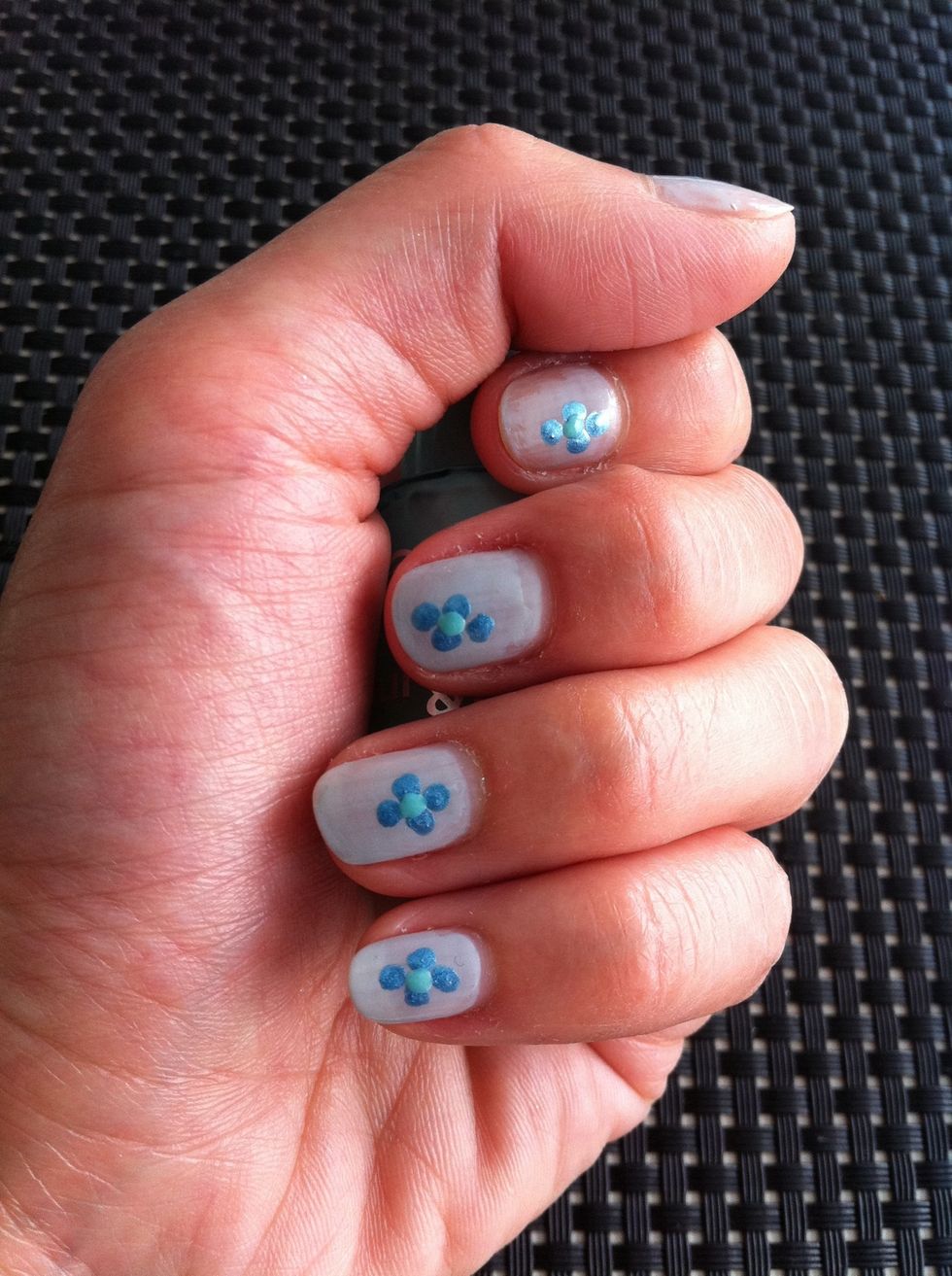 Tip 1 dot in the middle of the 4 dots to make it look like a flower. Repeat this for all your nails.