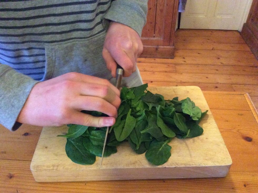Tip the dry spinach leaves onto a chopping board, and chop roughly with a large knife. This helps the spinach become easier to serve and to mix through.