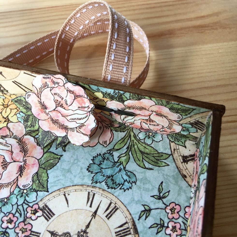 Tip: To hide the back of the brads fussy cut a small piece of paper, in this case a little flower, and adhere.