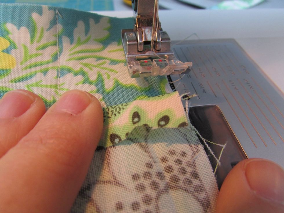 To add your edging trim, fold one edge down 1/4". Place along one long edge of the inside quilted fabric. Begin stitching a scant 1/2" from the edge to secure the trim.
