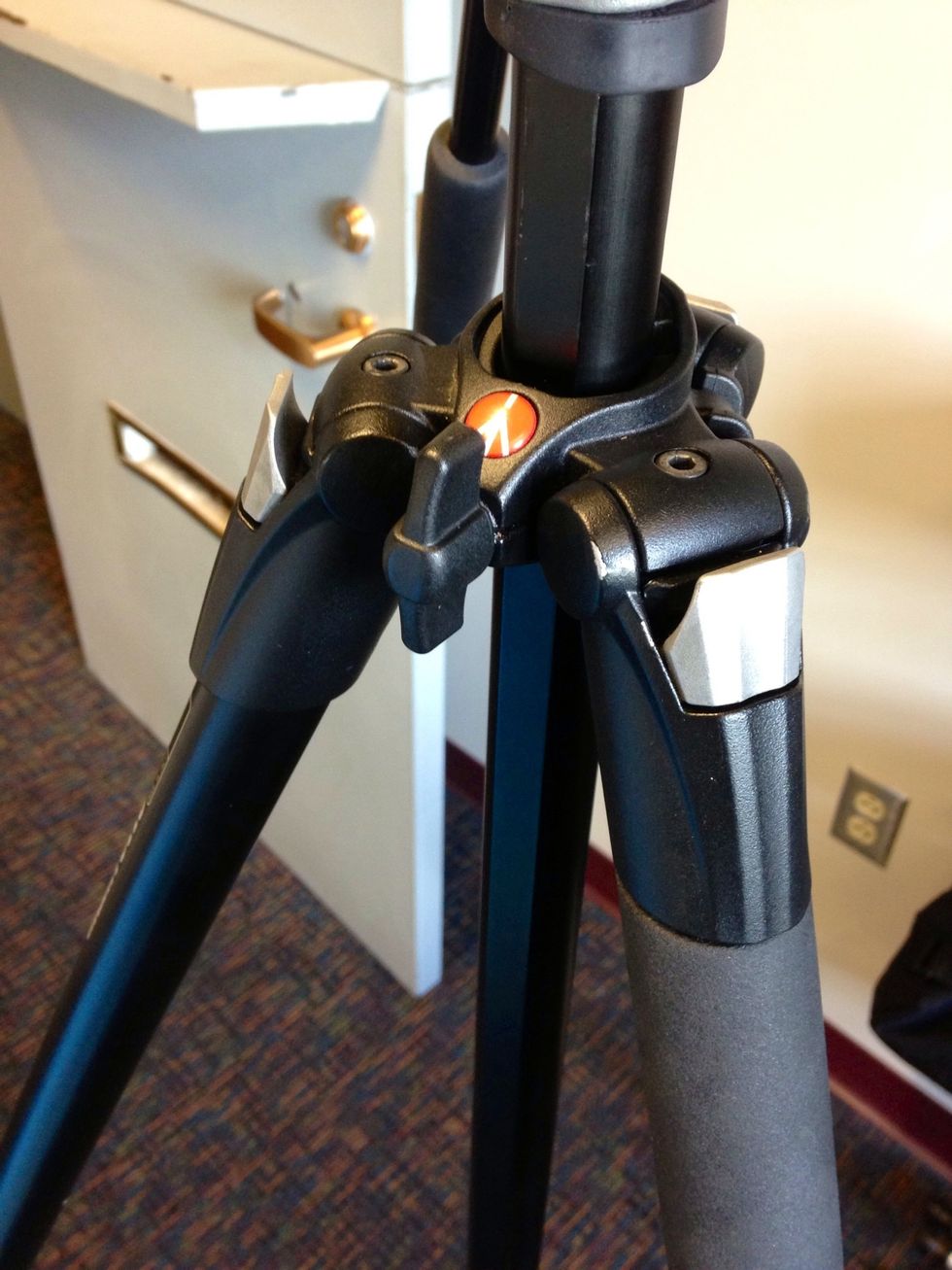 To adjust the height of the tripod, loosen the center column by turning the center knob. Raise the center column to a desired height, and then tighten the center knob.