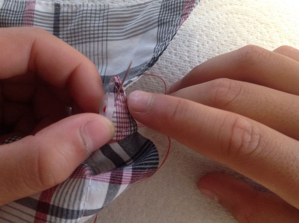 To anchor the button stitching, bring the needle up through the bottom of the material ONLY.  Make sure not to go through the button hole.