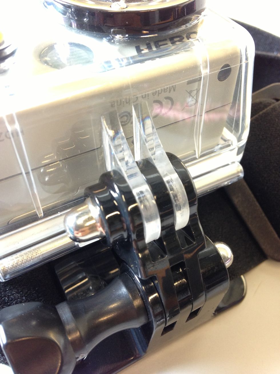 To attach the camera to a GoPro Head Strap mount, slide the two legs of the camera cover into the head strap plastic slots. You will have to twist out the screw beforehand if it is in the slots.