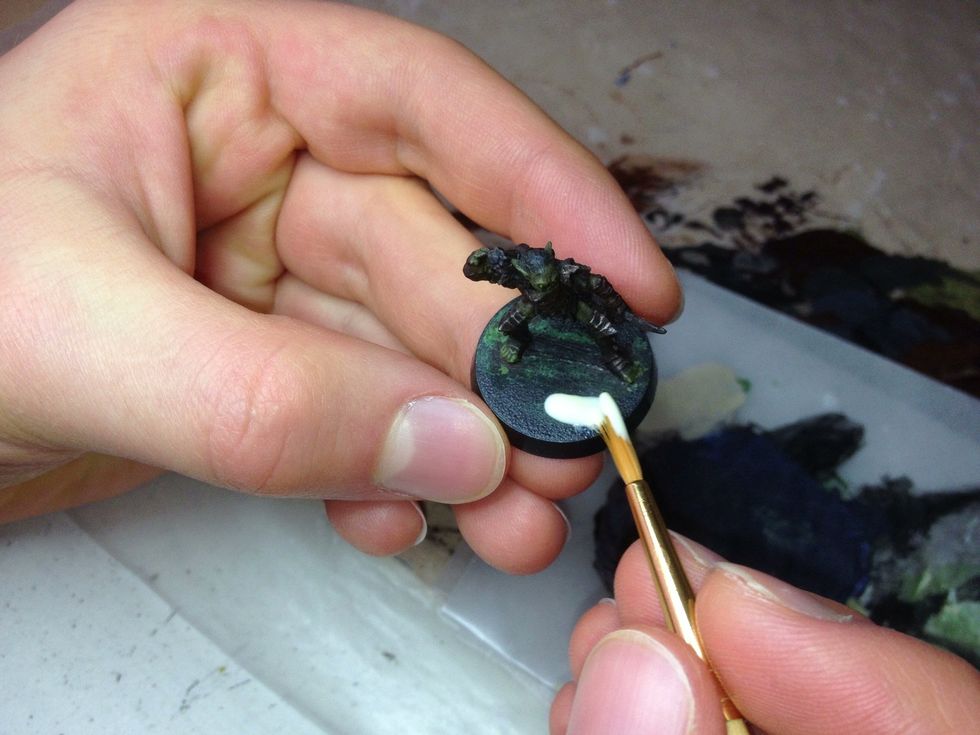 To begin detailing the base, we need to glue sand onto it. Start by covering the base with carpenter's glue.